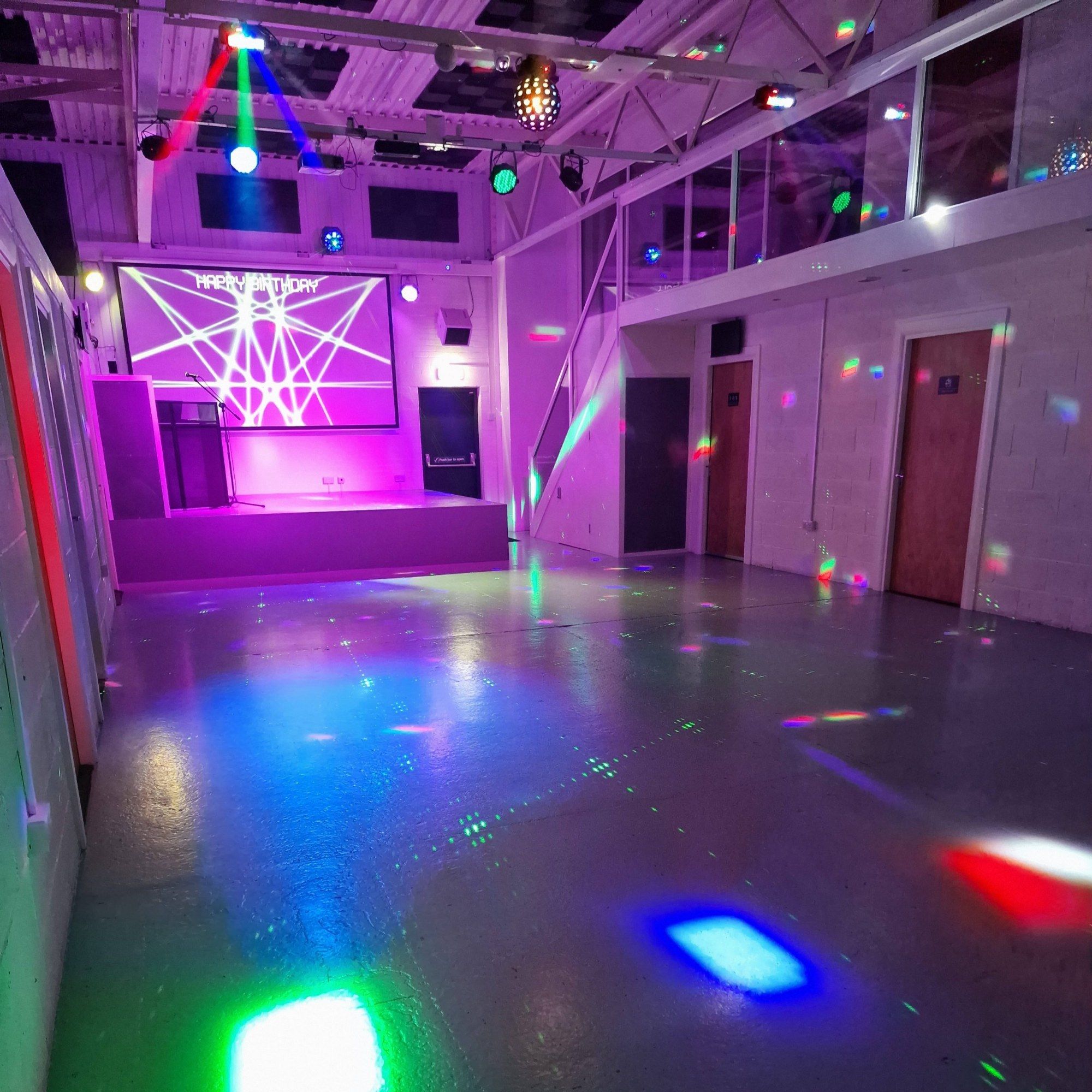 The main hall with disco lights on the floor and the stage at the far end